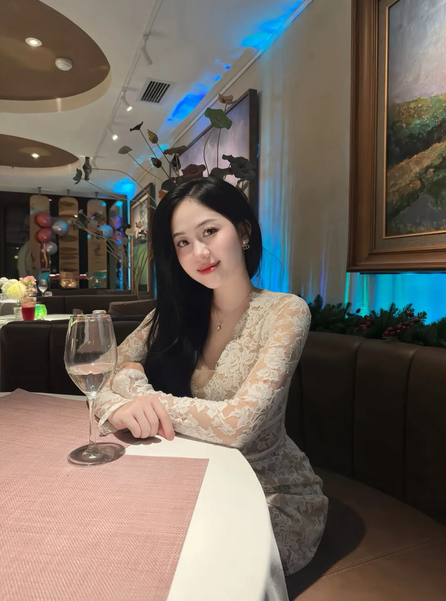 Captivating Beauty: Young Woman in Elegant Lace Dress Shines in Luxurious Restaurant Setting.