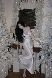 Christmas Muse: Elegant Beauty in a Backless Satin Dress by a Sparkling Tree - image 0