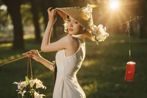 Serene Vietnamese Beauty in White Ao Dai with Lilies: A Golden Hour Portrait 1000025192 - image 2