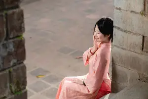 Graceful Asian Young Woman in Traditional Pink Attire: Timeless Beauty by an Ancient Wall - image 1