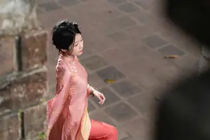 Graceful Asian Young Woman in Traditional Pink Attire: Timeless Beauty by an Ancient Wall - image 0