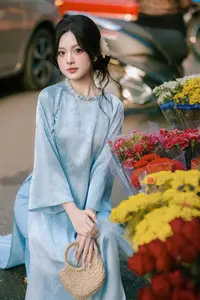 Traditional Vietnamese Beauty: Graceful Girl in Blue Ao Dai with Fresh Flowers - image 10