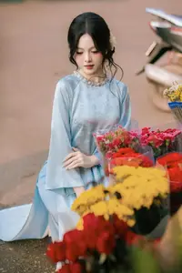 Traditional Vietnamese Beauty: Graceful Girl in Blue Ao Dai with Fresh Flowers - image 1