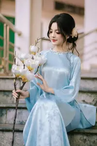 Traditional Vietnamese Beauty: Graceful Girl in Blue Ao Dai with Fresh Flowers - image 3