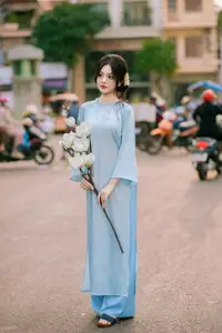 Traditional Vietnamese Beauty: Graceful Girl in Blue Ao Dai with Fresh Flowers - image 8