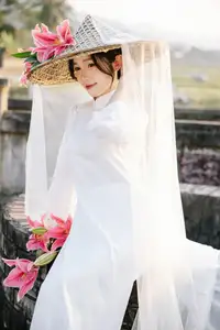 Discover the captivating grace of a Vietnamese woman in a flowing white Ao Dai and traditional conical hat - image 10