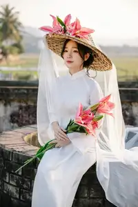 Discover the captivating grace of a Vietnamese woman in a flowing white Ao Dai and traditional conical hat - image 9