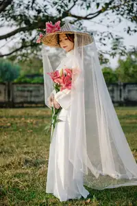 Discover the captivating grace of a Vietnamese woman in a flowing white Ao Dai and traditional conical hat - image 11