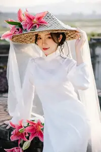 Discover the captivating grace of a Vietnamese woman in a flowing white Ao Dai and traditional conical hat - image 3