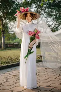 Discover the captivating grace of a Vietnamese woman in a flowing white Ao Dai and traditional conical hat - image 4
