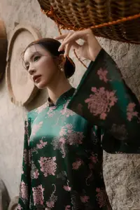Elegant Asian Beauty: Serene Woman in Modernized Traditional Dress with Vintage Floral Vase - image 0