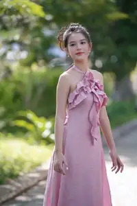 Gentle Charm: A Girl in an Elegant Pink Dress Amidst Nature's Embrace - image 0