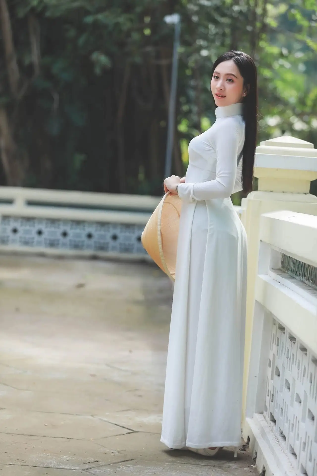 Elegant Vietnamese Woman in White Ao Dai: A Portrait of Traditional Grace and Conical Hat
