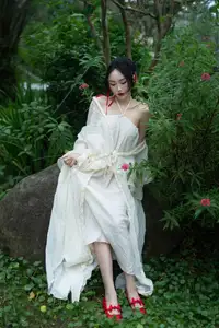 Elegant Woman in White Dress Amidst Lush Green Nature - image 1