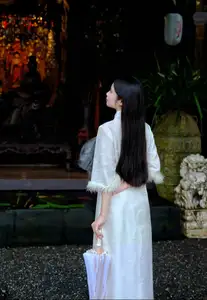 Graceful Vietnamese Woman in White Ao Dai with Lotus Flower in Serene Garden - image 4