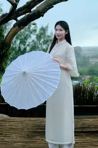 Graceful Vietnamese Woman in White Ao Dai with Lotus Flower in Serene Garden - image 0