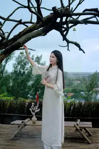 Graceful Vietnamese Woman in White Ao Dai with Lotus Flower in Serene Garden - image 3