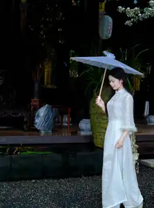 Graceful Vietnamese Woman in White Ao Dai with Lotus Flower in Serene Garden - image 1