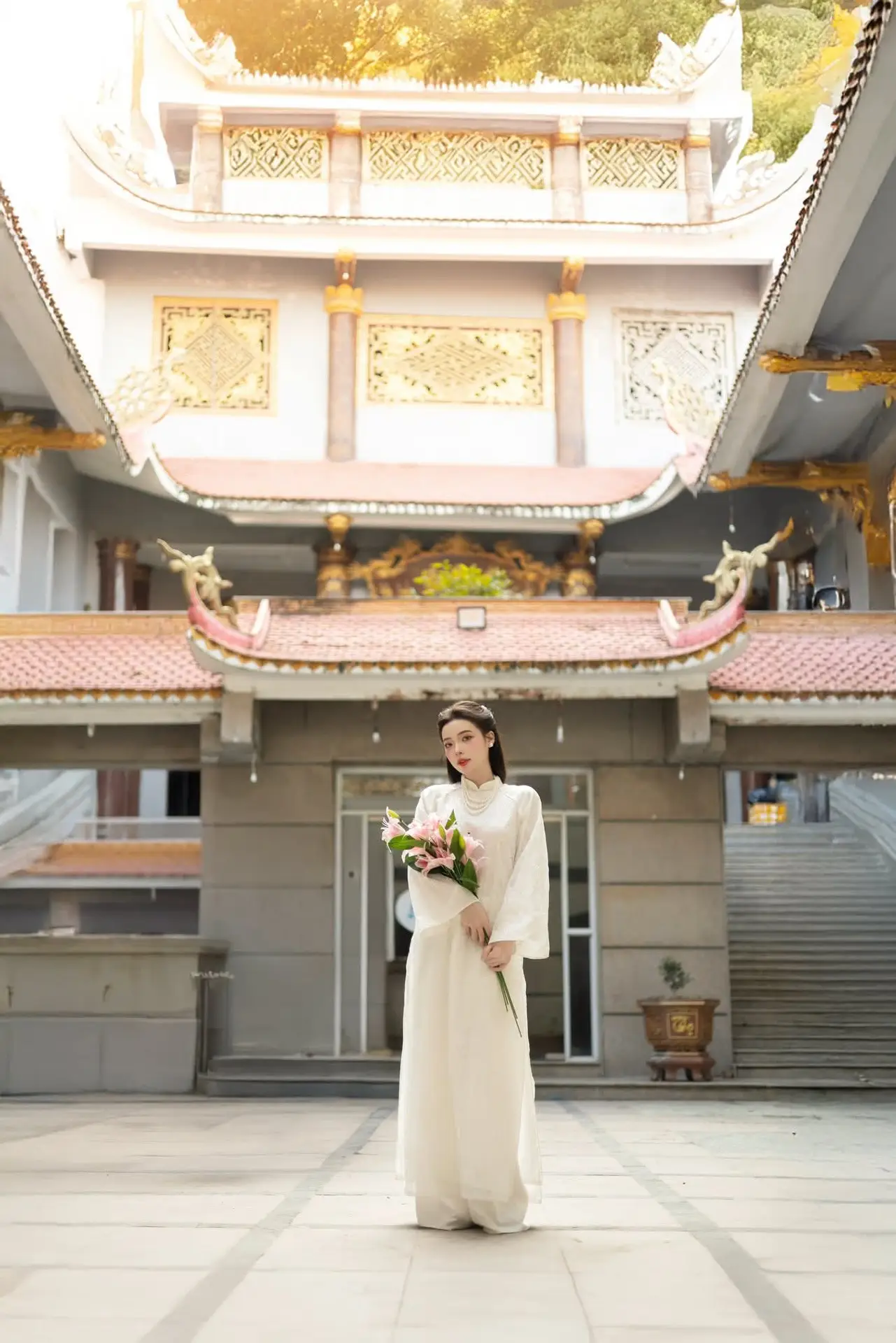 Serene Vietnamese Beauty: A Gentle Muse in White with Pink Lilies