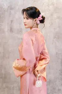 Elegant Asian Charm: Serene Young Woman in Traditional Pink Attire with Delicate Fresh Flowers - image 0