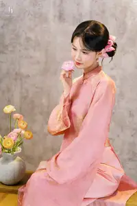 Elegant Asian Charm: Serene Young Woman in Traditional Pink Attire with Delicate Fresh Flowers - image 3