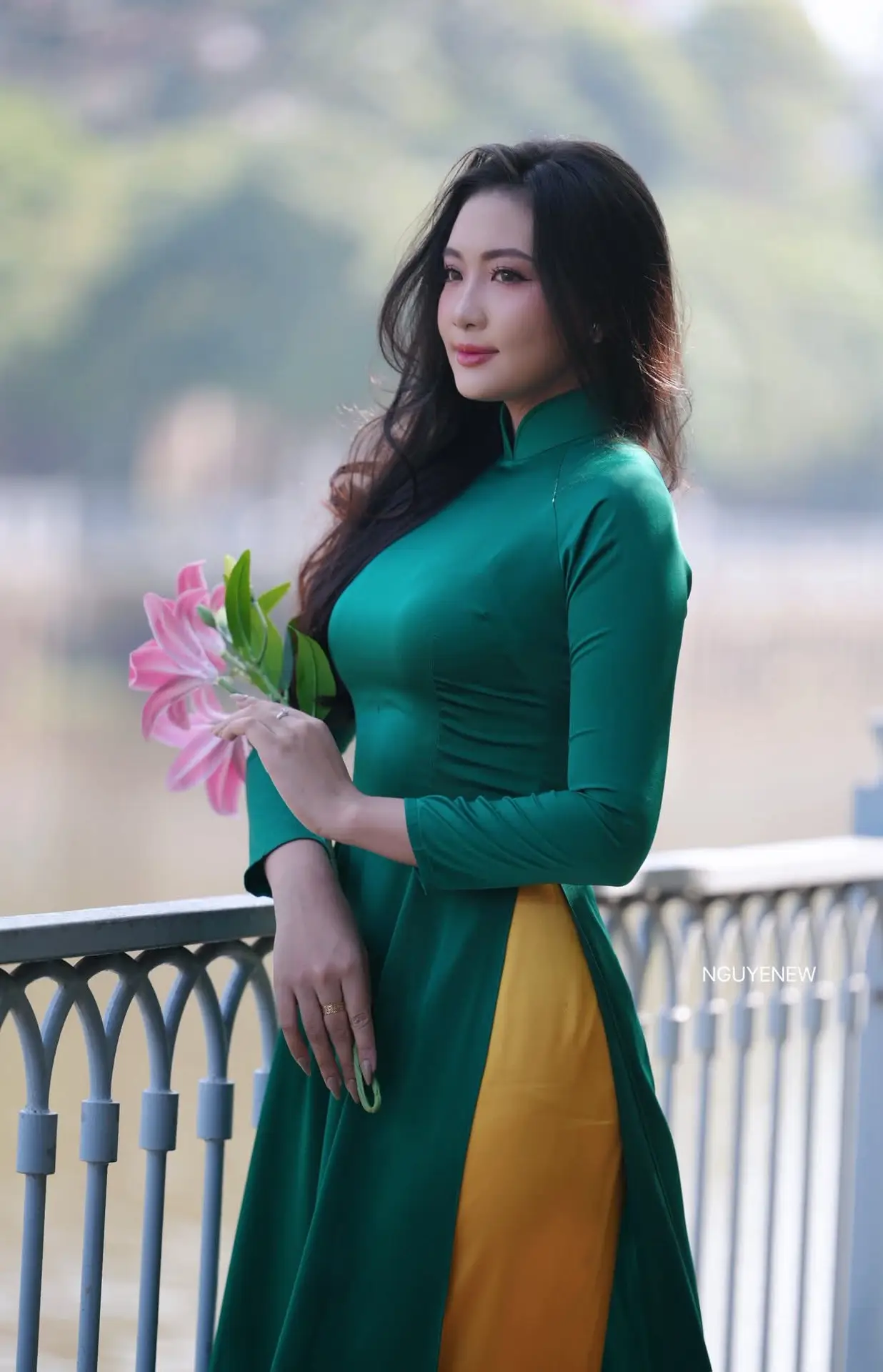 Vietnamese Grace: Elegant Woman in Green Ao Dai with Pink Lotus Flower 1000025232