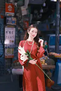 Elegant Vietnamese Beauty: A Girl in Red Ao Dai with Lilies Captivates Urban Charm - image 1