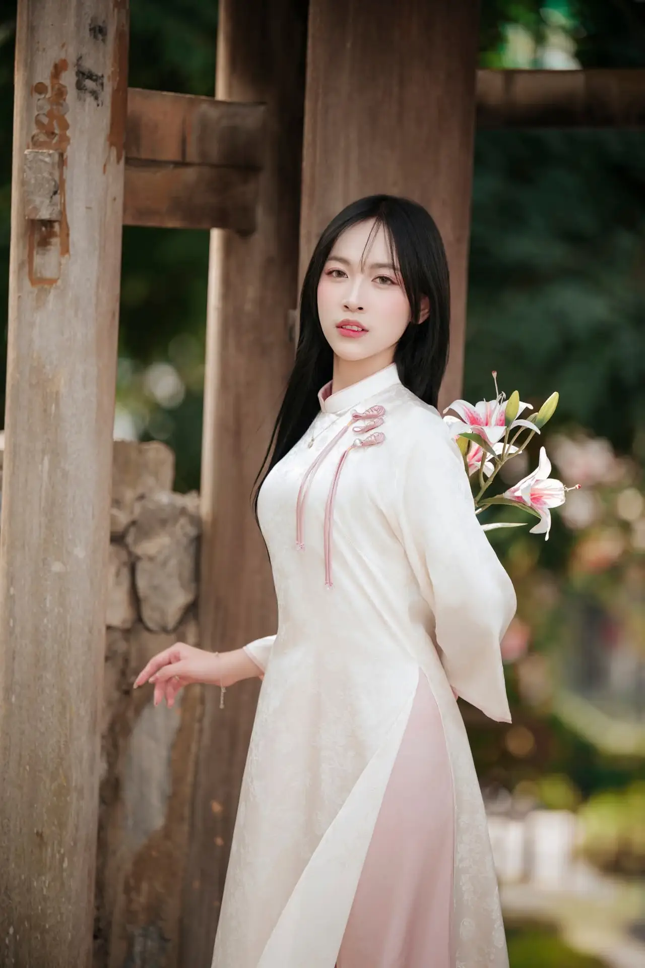 Timeless Elegance: Vietnamese Woman in Traditional Ao Dai Amidst Serene Backdrop