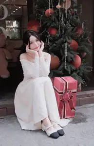 Elegant Girl in Off-Shoulder White Dress Welcoming Christmas, Showcasing Gentle Beauty and Holiday Season Style. 1000027390 - image 0