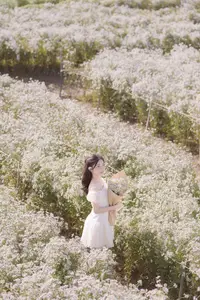 Ethereal Beauty: Young Woman in White Dress with Bouquet Amidst Dreamy Clouds - image 0