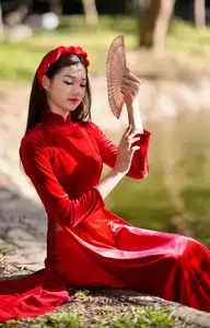 Discover the enchanting beauty of a Vietnamese woman in a traditional Red Ao Dai by the tranquil water. - image 4