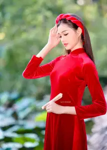 Discover the enchanting beauty of a Vietnamese woman in a traditional Red Ao Dai by the tranquil water. - image 6