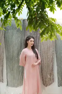 Discover Serene Vietnamese Beauty: Elegant Woman in Pink Linen Dress Amidst Floral Charm - image 0