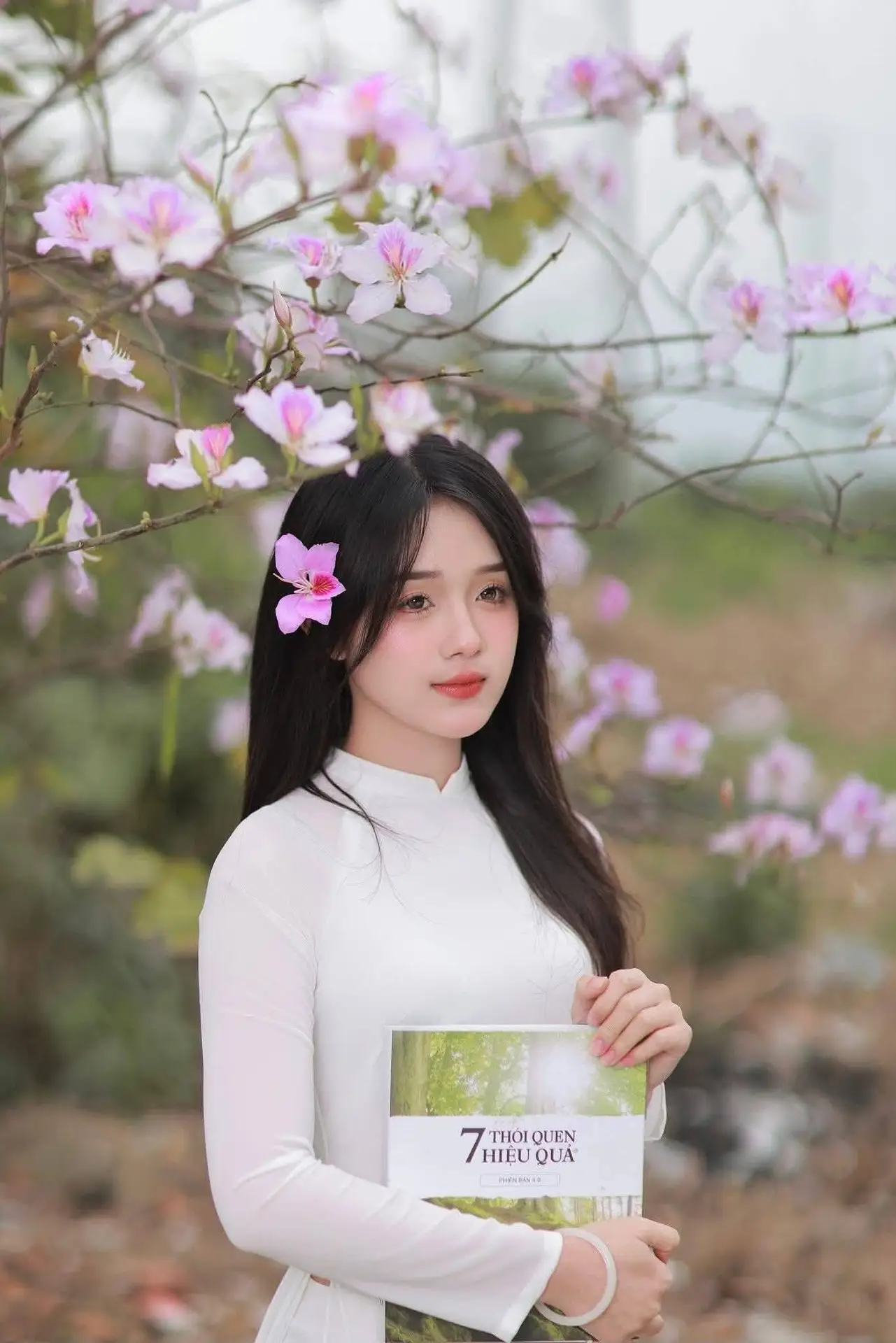Elegant Vietnamese Student in Ao Dai Amidst Bauhinia Flowers