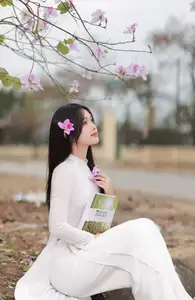 Elegant Vietnamese Student in Ao Dai Amidst Bauhinia Flowers - image 4