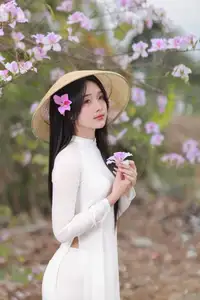 Elegant Vietnamese Student in Ao Dai Amidst Bauhinia Flowers - image 2