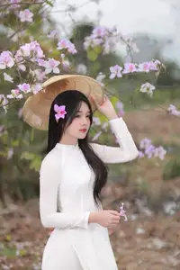 Elegant Vietnamese Student in Ao Dai Amidst Bauhinia Flowers - image 3